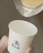 Load and play video in Gallery viewer, Hand holding a white Café Real espresso cup
